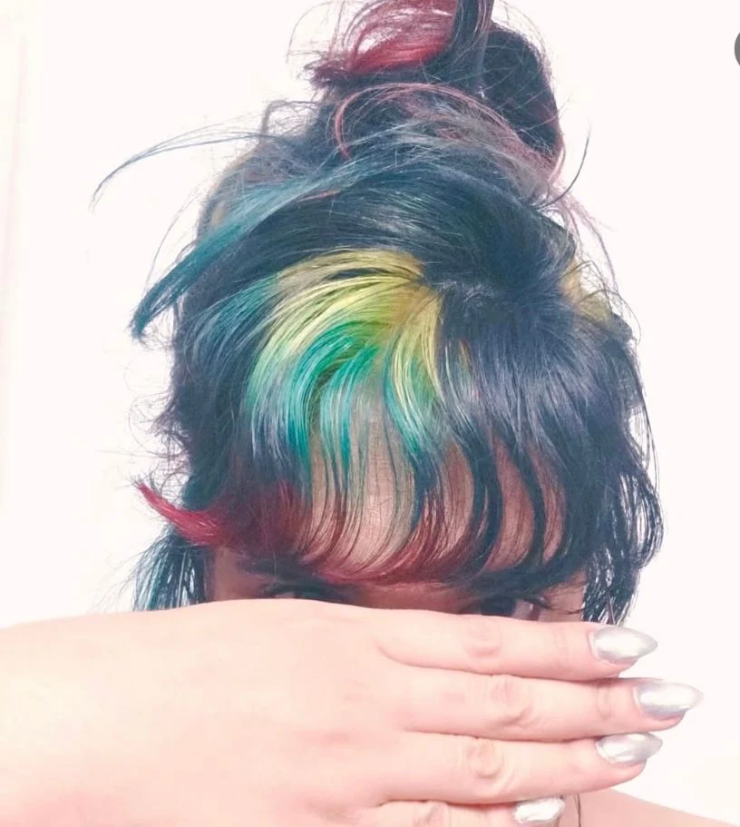 Dark hair with teal, yellow and red accent color by Stephanie Thomas at Gypsy Cosmo Salon
